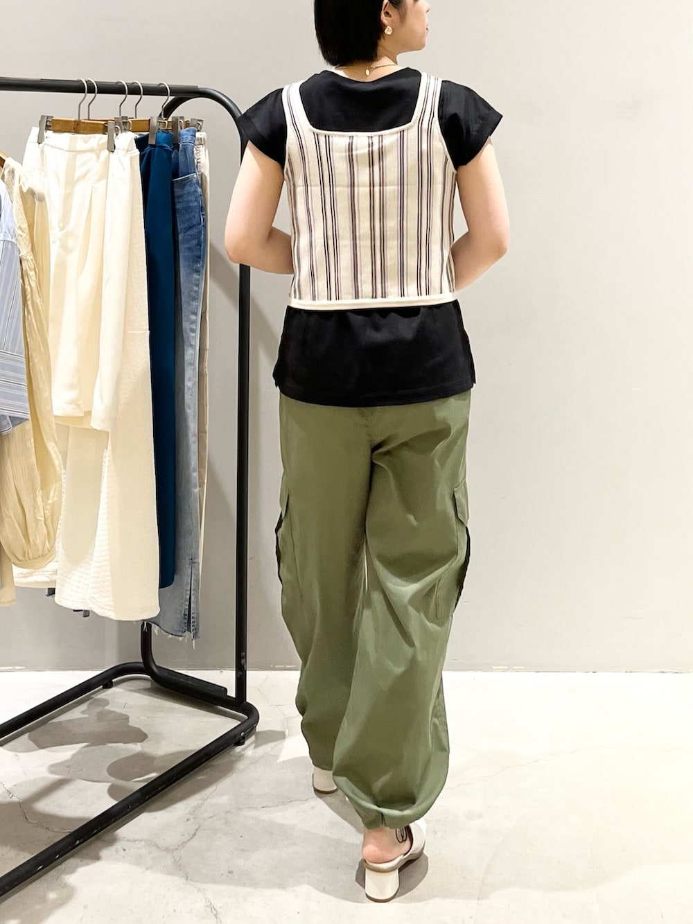 ベージュ系のタンクトップ、ブラック系のTシャツ/カットソー、グリーン系のパンツを着用したレディースの夏コーディネートの4枚目の写真