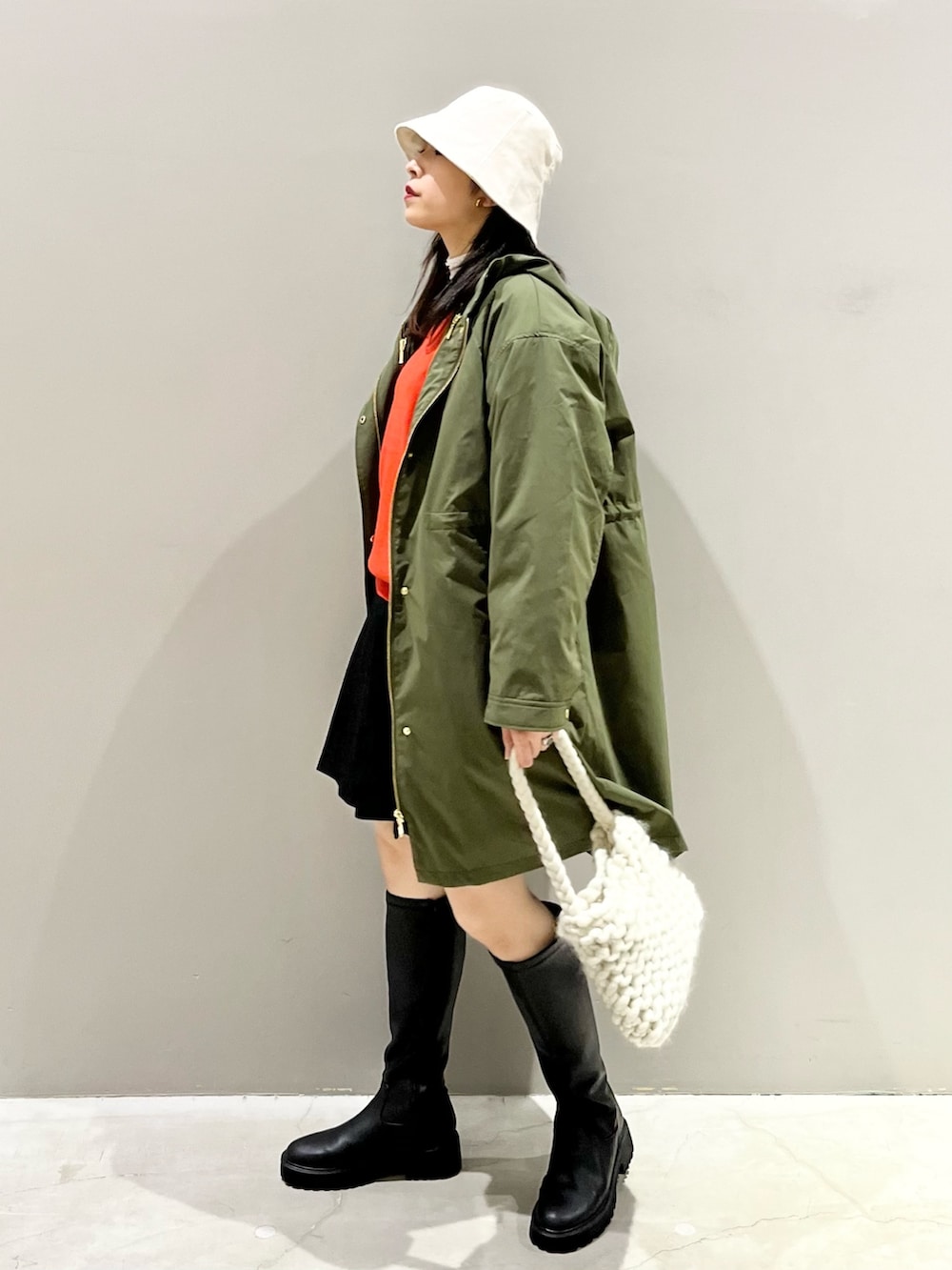 ブラック系のパンツ、ブラック系のブーツ、ホワイト系のバッグを着用したレディースの秋コーディネートの3枚目の写真