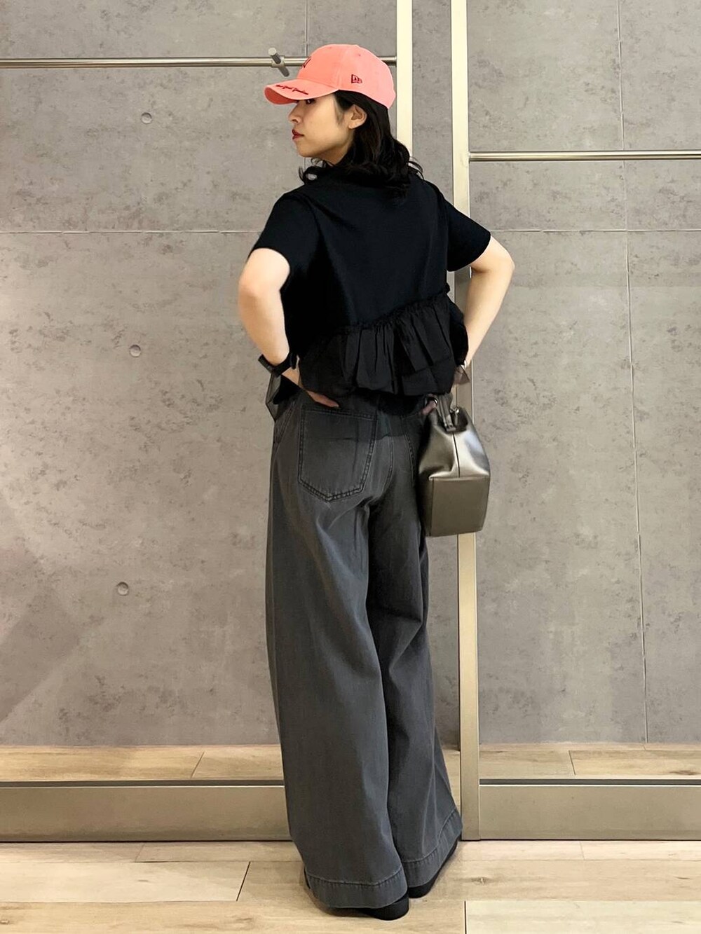 シルバー系のサンダル、ブラック系のデニムパンツ、ホワイト系のショルダーバッグを着用したレディースの春コーディネートの3枚目の写真