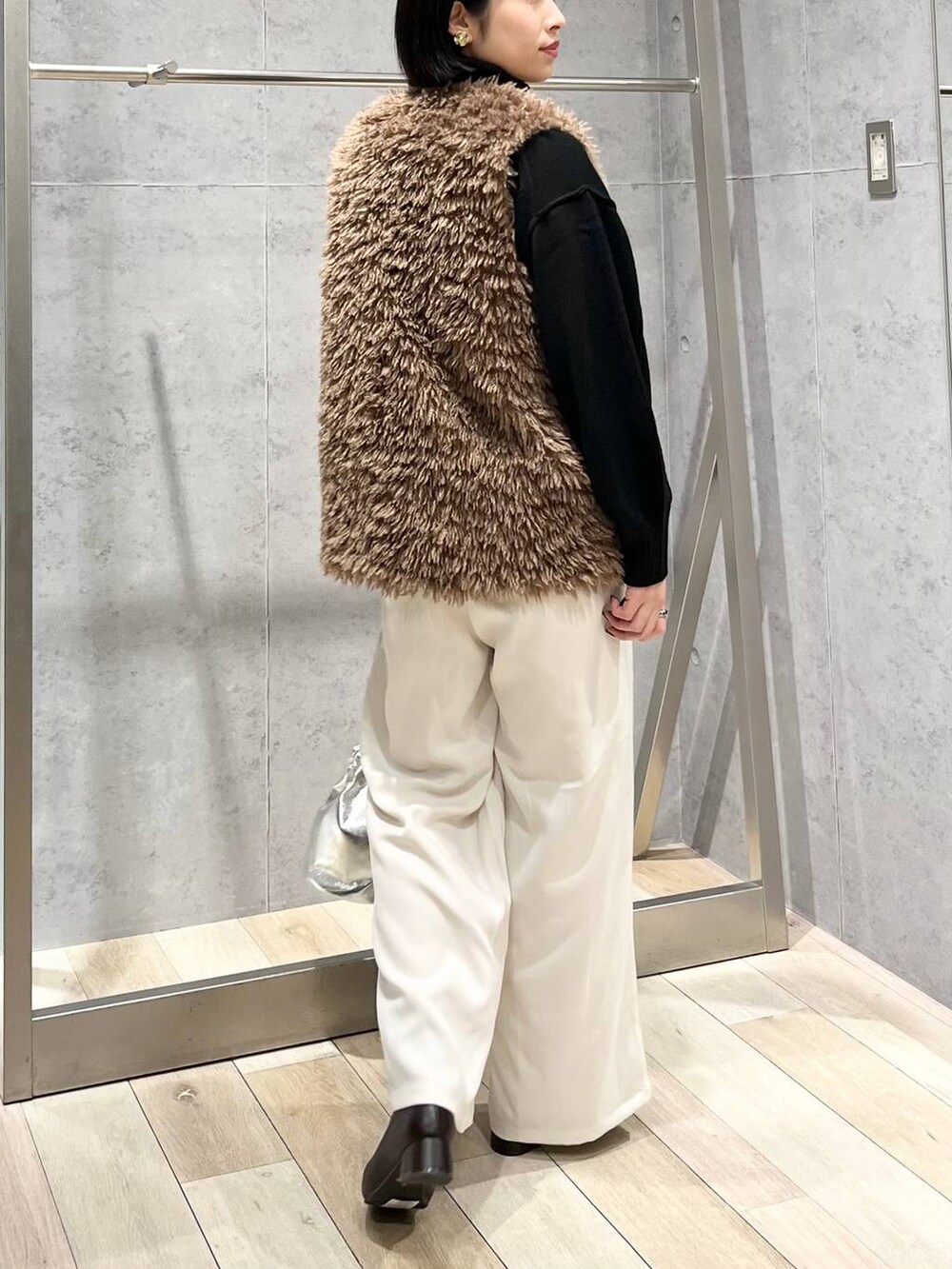 ブラック系のニット/セーター、ブラウン系のブーツ、ホワイト系のその他パンツを着用したレディースの秋コーディネートの4枚目の写真