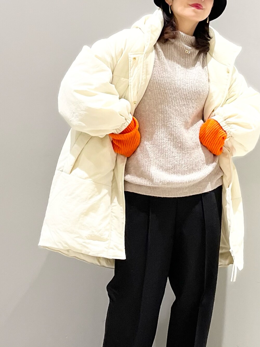 ブラウン系のニット/セーター、ホワイト系のジャケット/アウター、ブラック系のパンツを着用したレディースの冬コーディネートの4枚目の写真