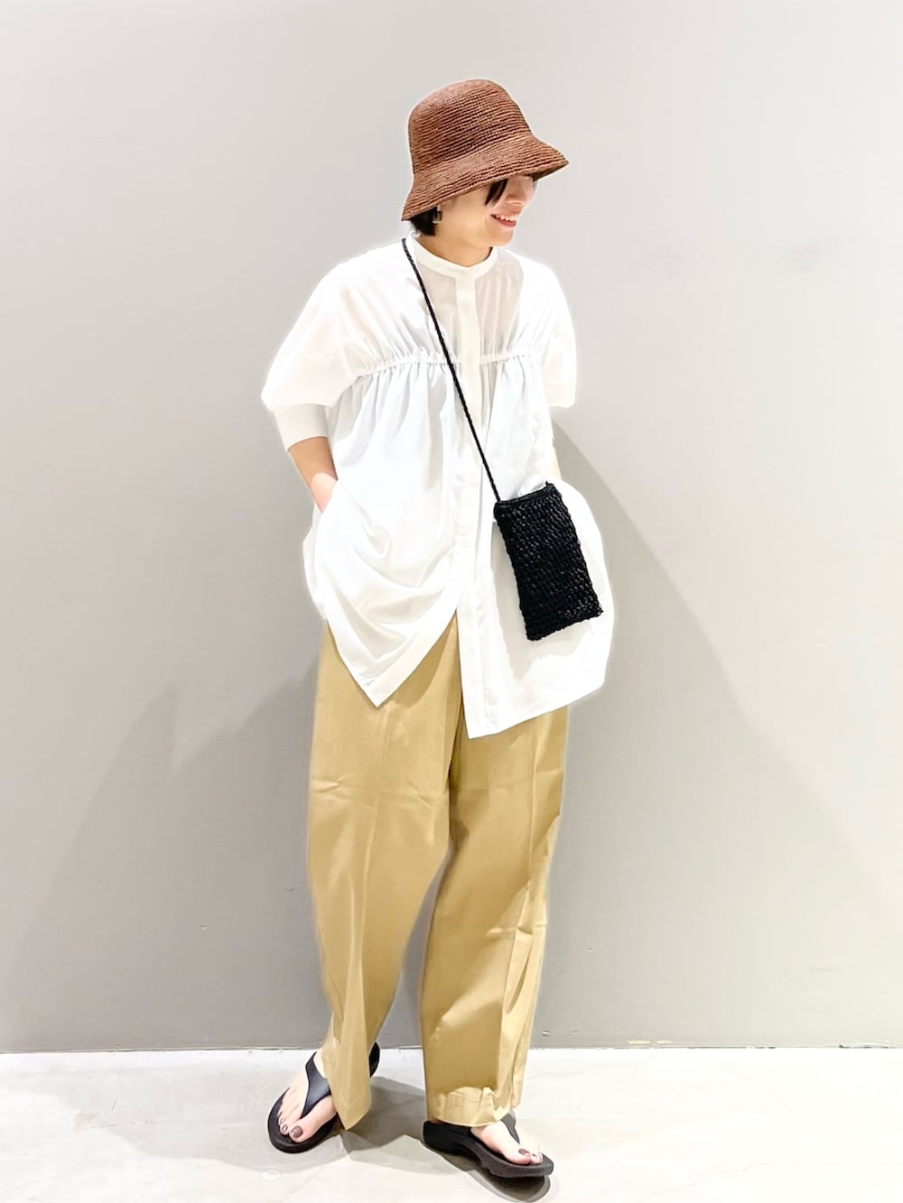 ブラック系のサンダル、ベージュ系のチノパンツ、ブラック系のショルダーバッグを着用したレディースの夏コーディネートの3枚目の写真