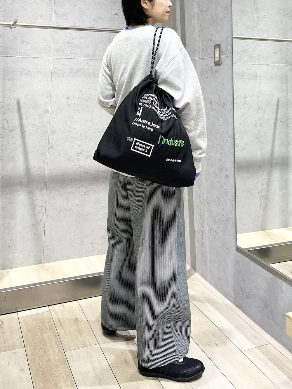 ブラック系のパンプス、ブラック系のトートバッグ、グレー系のTシャツ/カットソーを着用したレディースの冬コーディネートの4枚目の写真