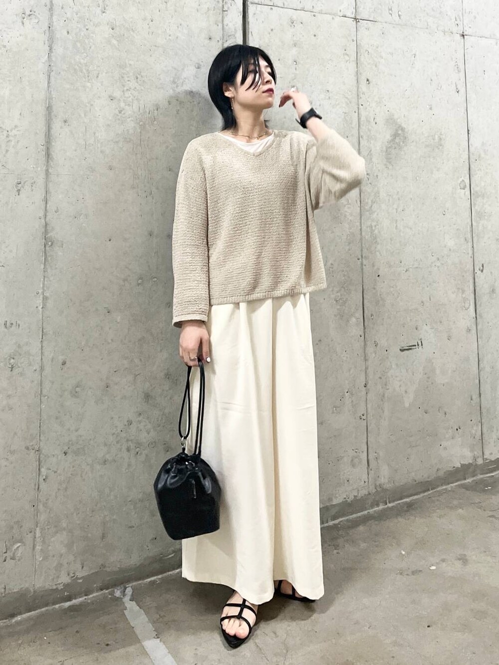 ブラック系のショルダーバッグ、ブラック系のサンダル、ホワイト系のTシャツ/カットソーを着用したレディースの春コーディネートの5枚目の写真