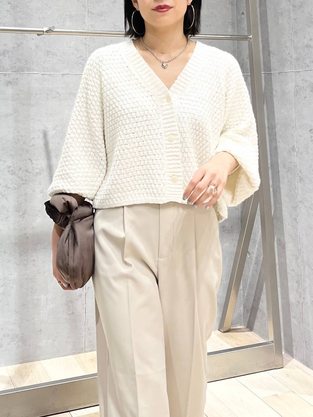 ブラウン系のハンドバッグ、グレー系のパンプス、ホワイト系のカーディガン/ボレロを着用したレディースの冬コーディネートの8枚目の写真