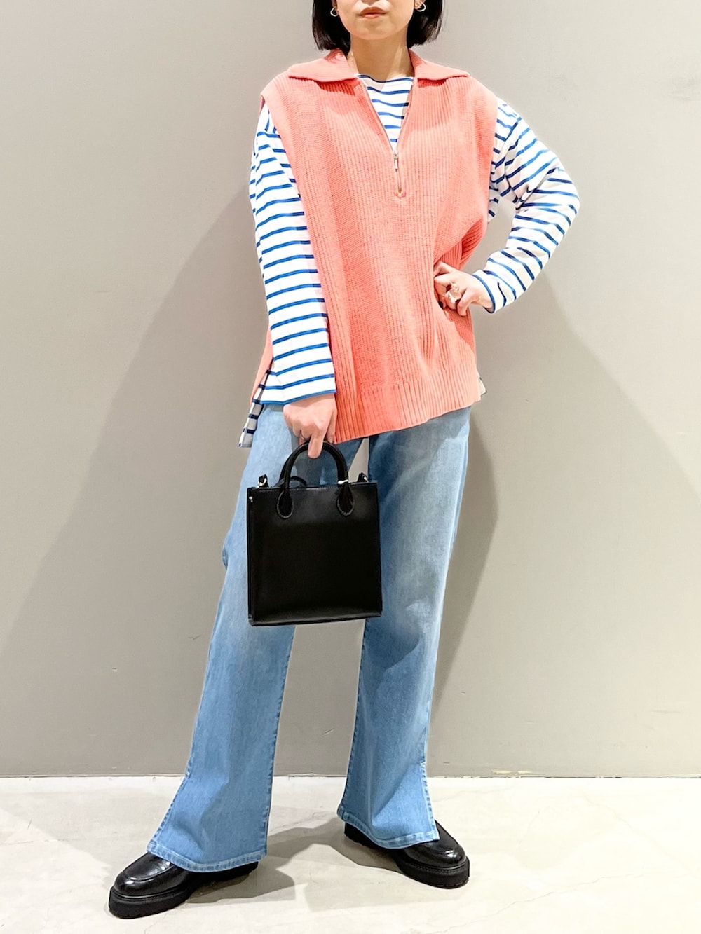 ブルー系のデニムパンツ、ブラック系のローファー、ブラック系のショルダーバッグを着用したレディースの春コーディネートの5枚目の写真