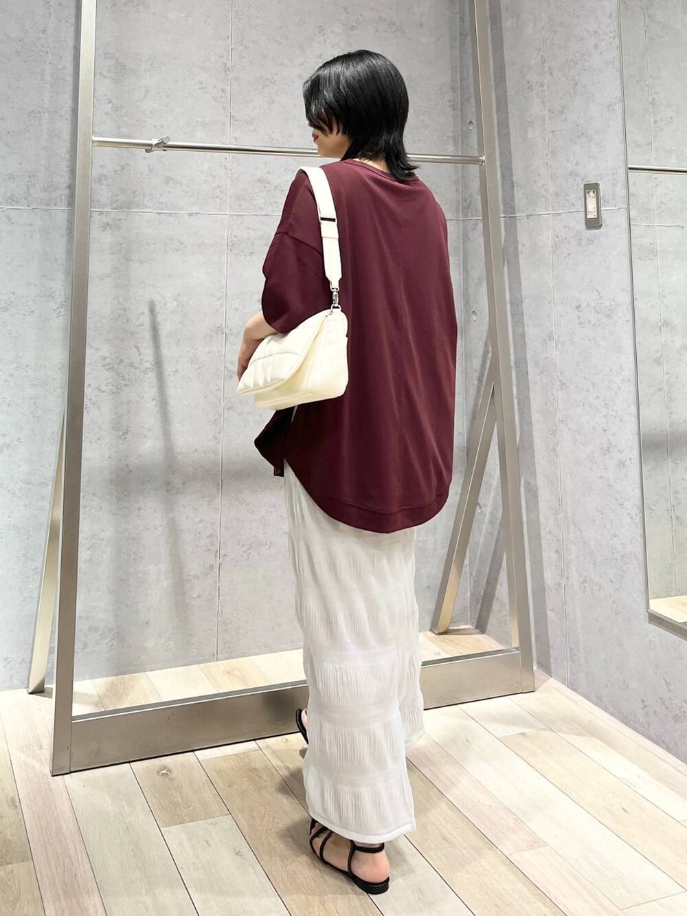 ホワイト系のショルダーバッグ、ブラック系のサンダル、レッド系のTシャツ/カットソーを着用したレディースの夏コーディネートの4枚目の写真