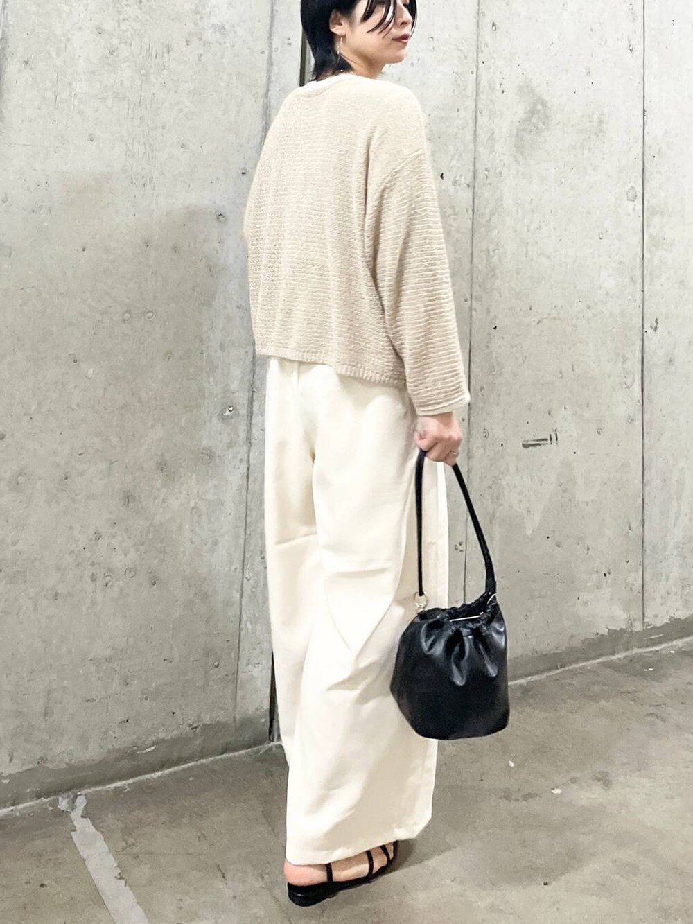 ブラック系のショルダーバッグ、ブラック系のサンダル、ホワイト系のTシャツ/カットソーを着用したレディースの春コーディネートの3枚目の写真