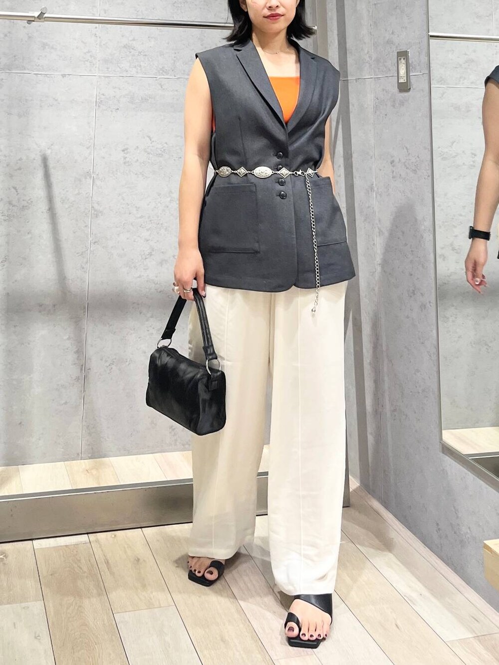 ホワイト系のその他パンツ、オレンジ系のタンクトップ、ブラック系のハンドバッグを着用したレディースの夏コーディネートの4枚目の写真