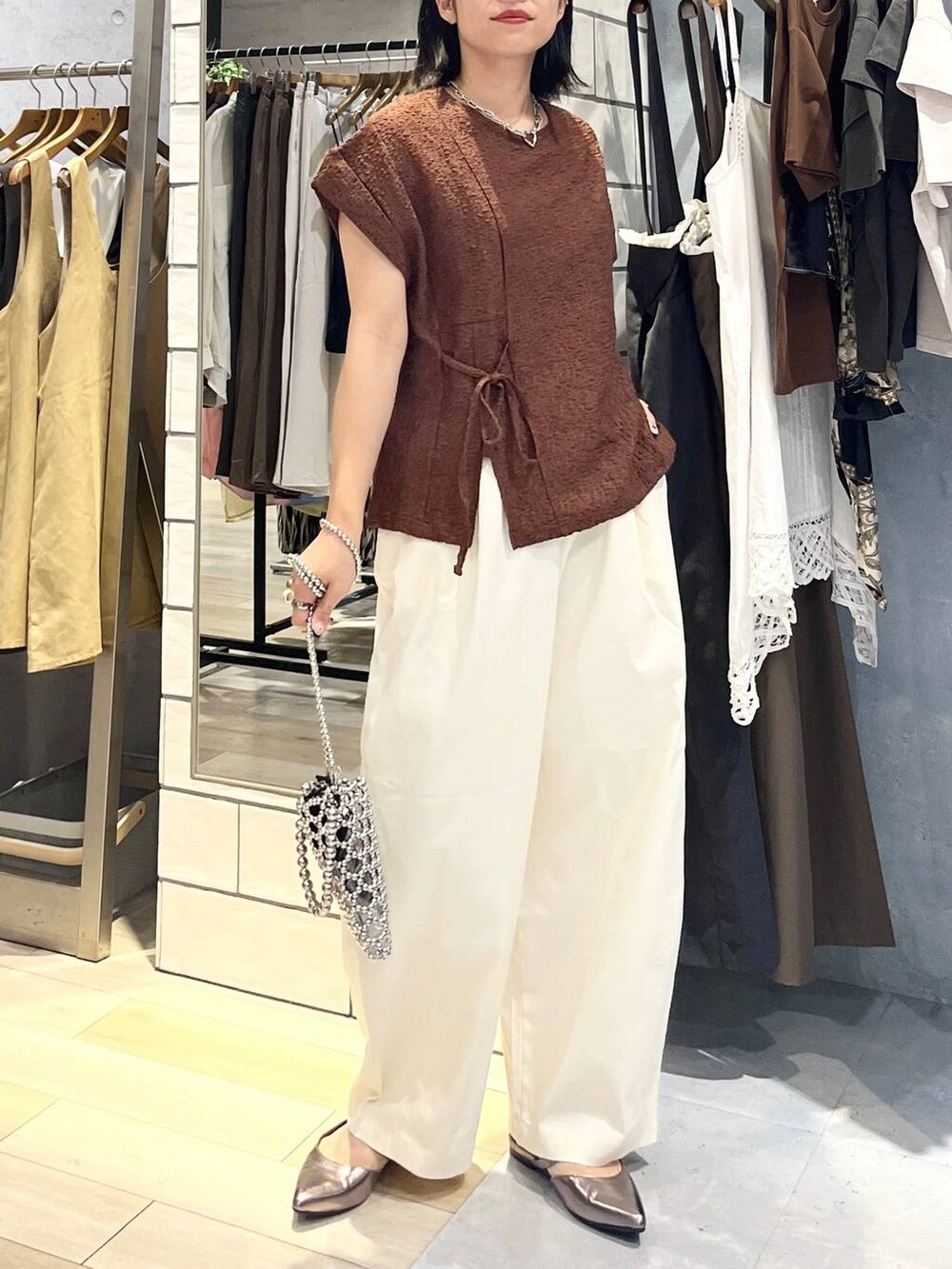 シルバー系のショルダーバッグ、ブラウン系のTシャツ/カットソー、ホワイト系のその他パンツを着用したレディースの夏コーディネートの6枚目の写真