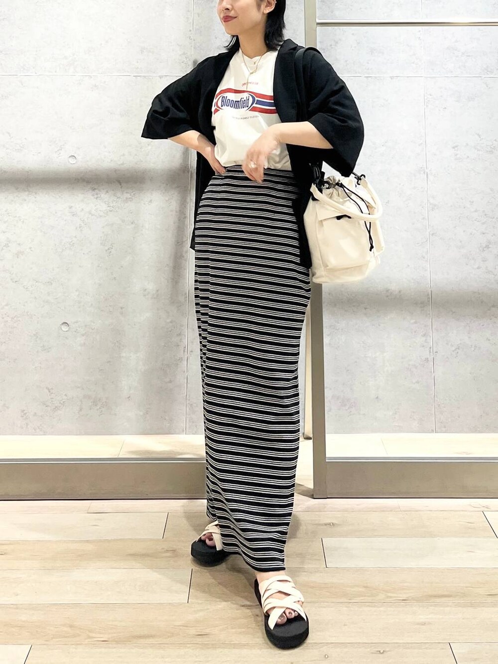 ブラック系のテーラードジャケット、ホワイト系のショルダーバッグ、ホワイト系のTシャツ/カットソーを着用したレディースの夏コーディネートの2枚目の写真