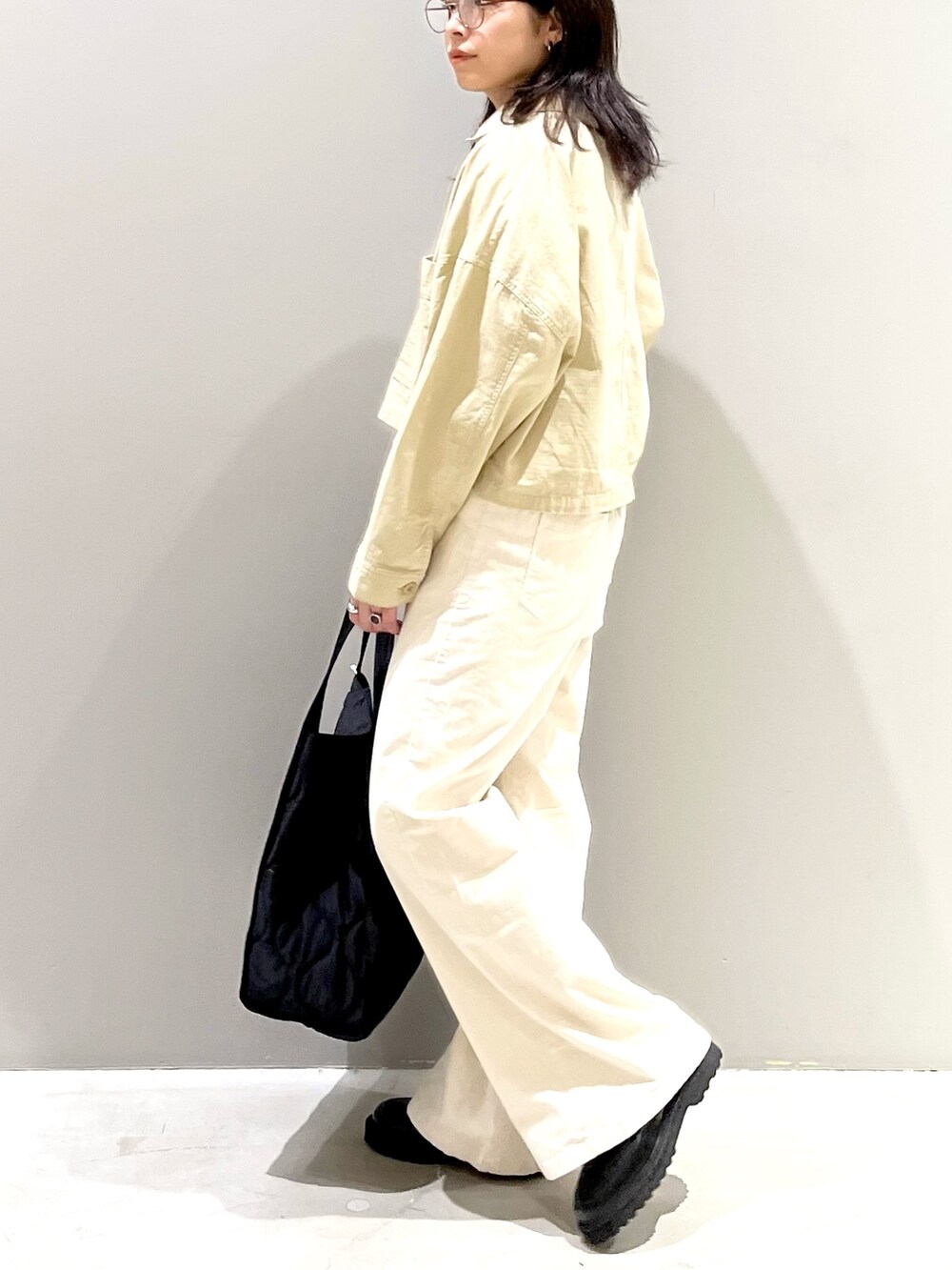ベージュ系のジャケット/アウター、ホワイト系のパンツ、ブラック系のバッグを着用したレディースの秋コーディネートの2枚目の写真