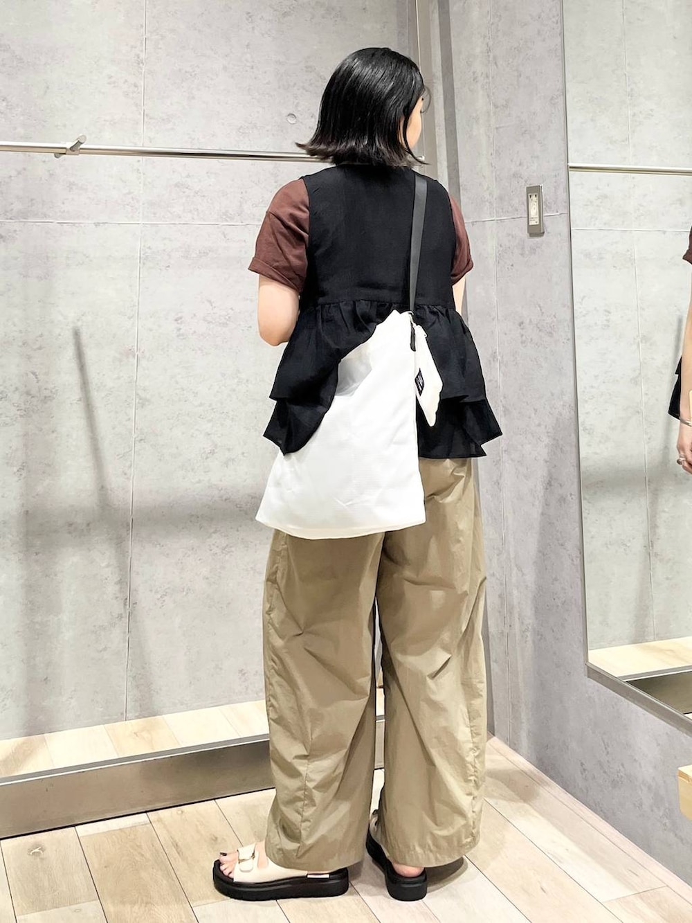 ホワイト系のサンダル、ブラック系のベスト、ブラウン系のTシャツ/カットソーを着用したレディースの夏コーディネートの4枚目の写真