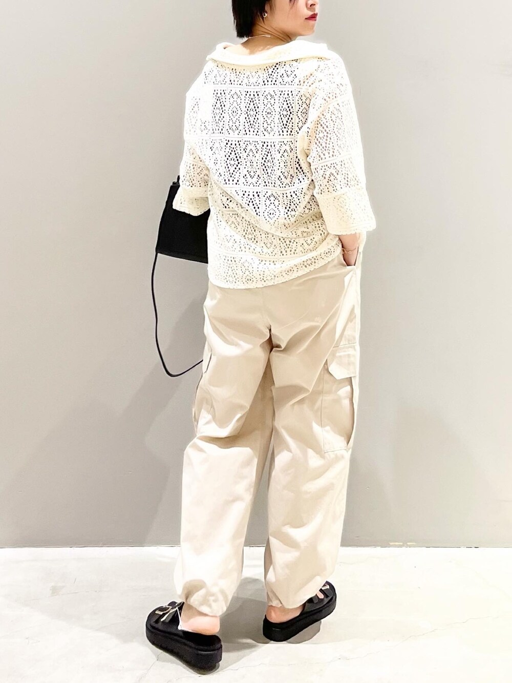 グリーン系のパンツ、ブラック系のサンダル、ブラック系のショルダーバッグを着用したレディースの春コーディネートの3枚目の写真