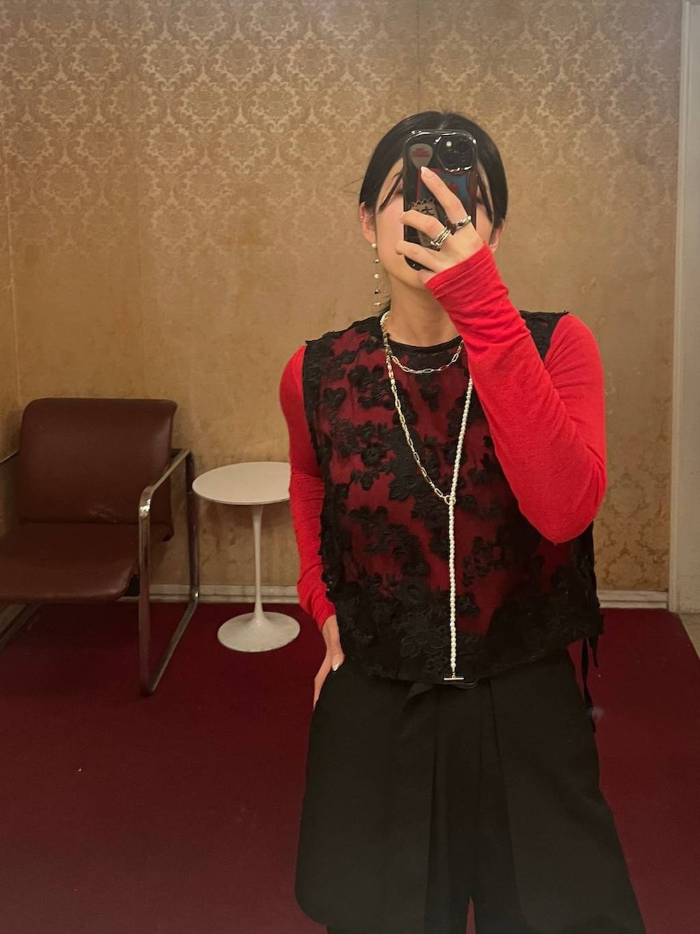 レッド系のTシャツ/カットソー、ブラック系のショルダーバッグ、ブラック系のその他パンツを着用したレディースの冬コーディネートの3枚目の写真