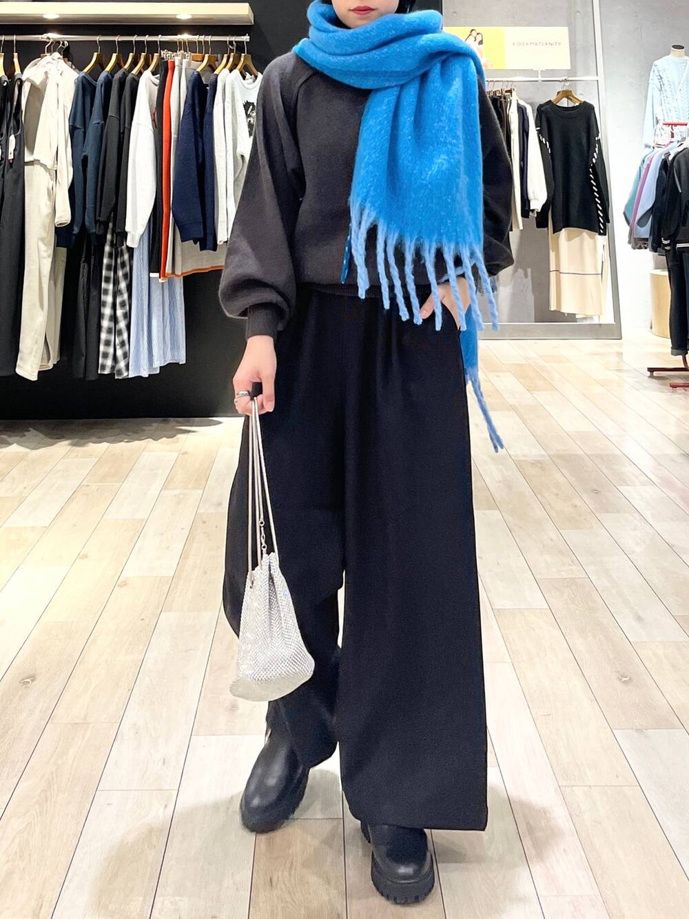 シルバー系のショルダーバッグ、グレー系のニット/セーター、ブラック系のその他パンツを着用したレディースの秋コーディネートの5枚目の写真