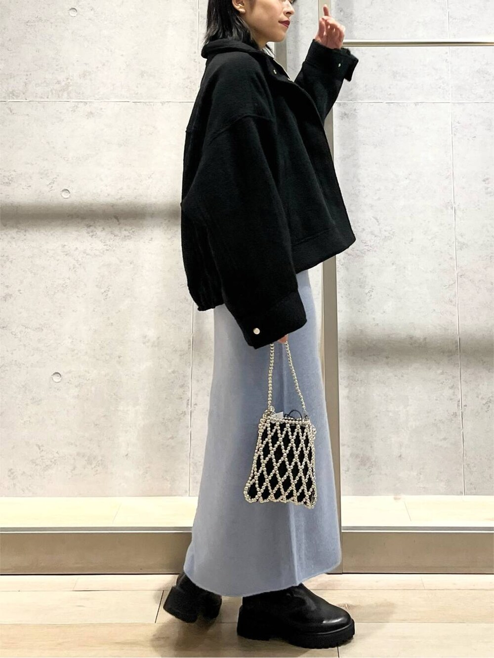 ブラック系のブルゾン、ブルー系のワンピース、ブラック系のブーツを着用したレディースの秋コーディネートの4枚目の写真