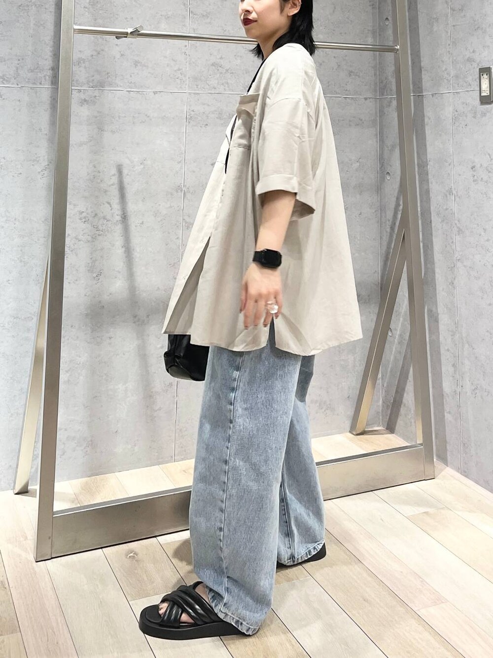 ブラック系のTシャツ/カットソー、ブラック系のサンダル、ブルー系のデニムパンツを着用したレディースの夏コーディネートの3枚目の写真