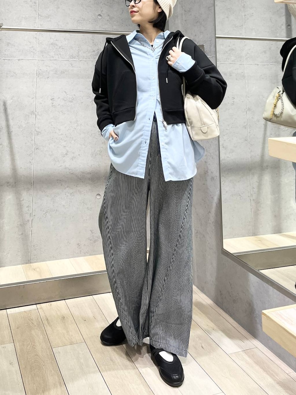 ブルー系のシャツ/ブラウス、ブラック系のボストンバッグ、ブラック系のパンプスを着用したレディースの冬コーディネートの5枚目の写真