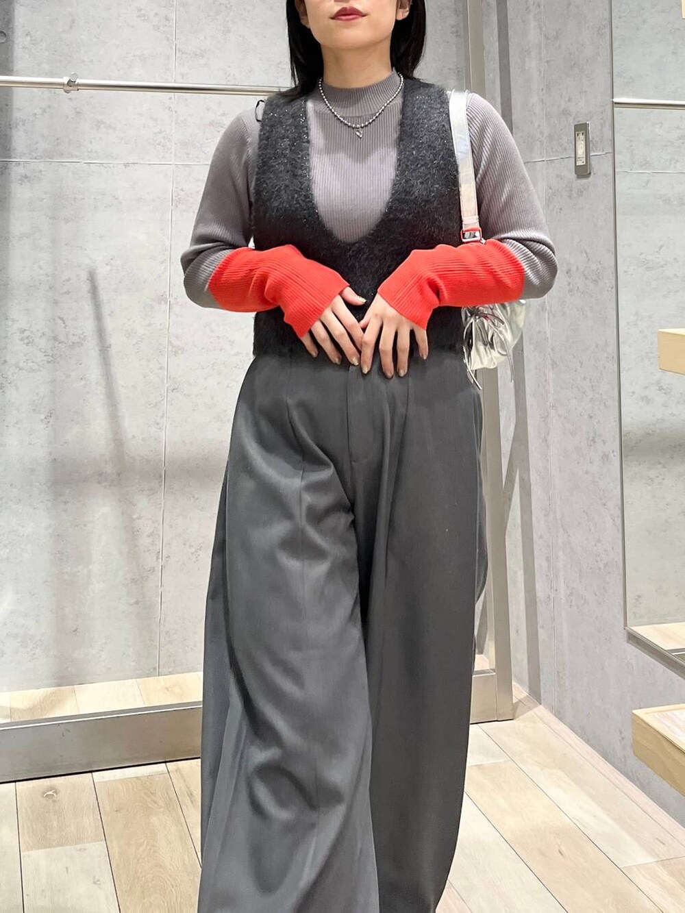 グレー系のニット/セーター、グレー系のベスト、グレー系のショルダーバッグを着用したレディースの冬コーディネートの3枚目の写真