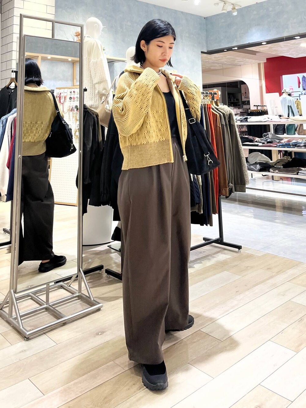 ブラウン系のその他パンツ、ブラック系のその他シューズ、ブラック系のショルダーバッグを着用したレディースの冬コーディネートの6枚目の写真
