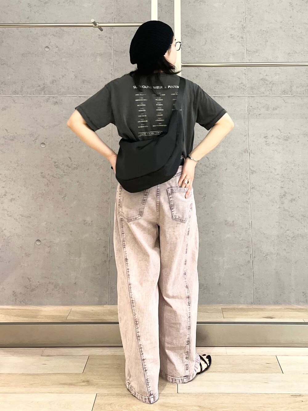 パープル系のデニムパンツ、ブラック系のショルダーバッグ、ブラック系のTシャツ/カットソーを着用したレディースの春コーディネートの5枚目の写真