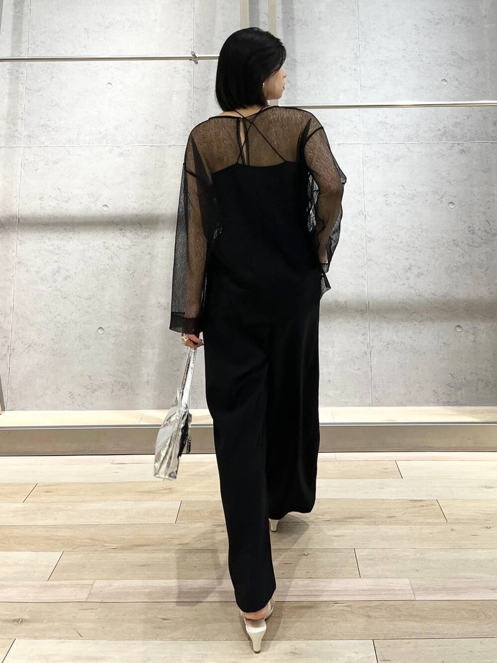 シルバー系のハンドバッグ、ブラック系のシャツ/ブラウス、ブラック系のスラックスを着用したレディースの冬コーディネートの7枚目の写真