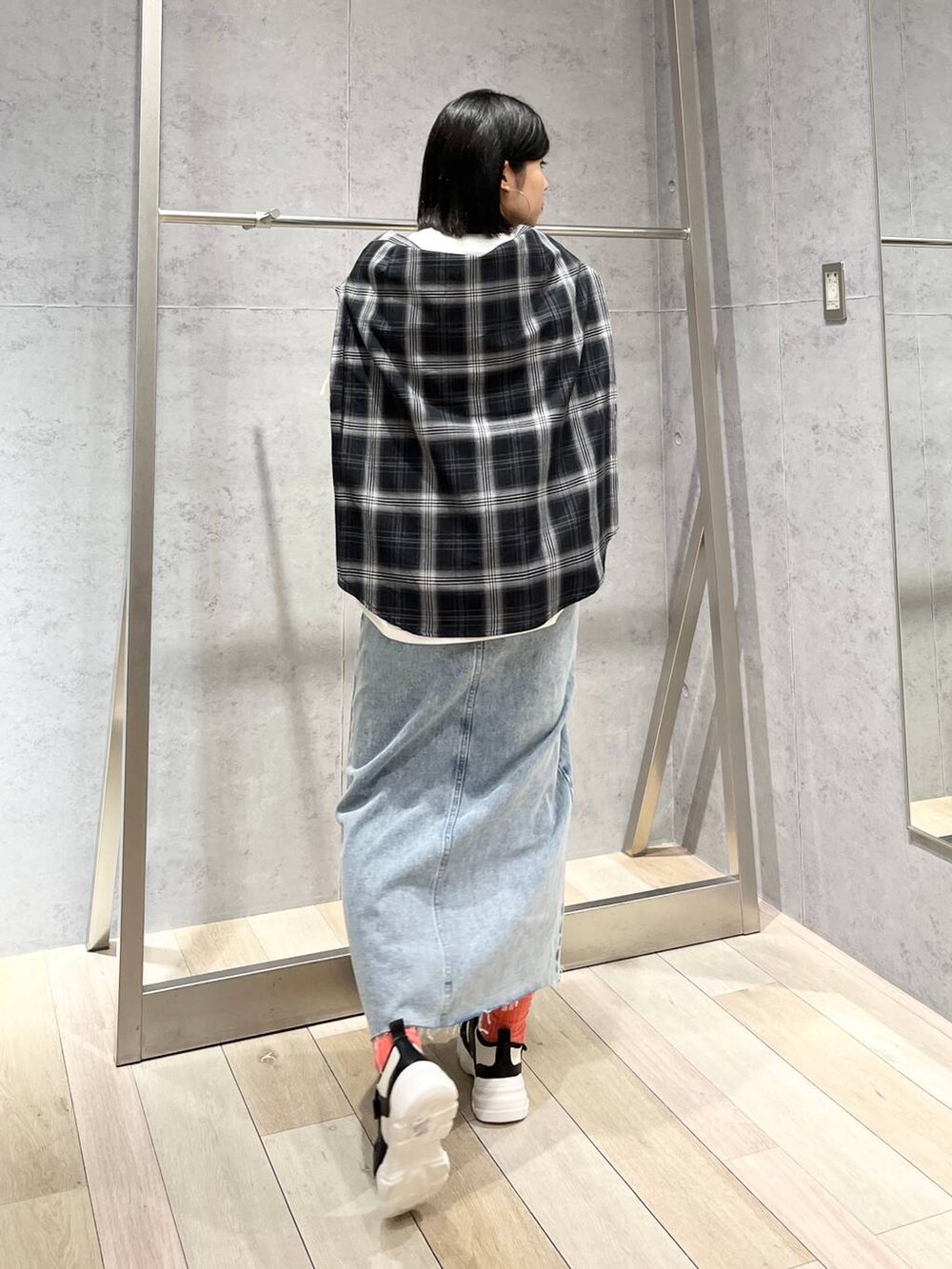 ホワイト系のTシャツ/カットソー、ブルー系のスカート、ホワイト系のスニーカーを着用したレディースの冬コーディネートの4枚目の写真