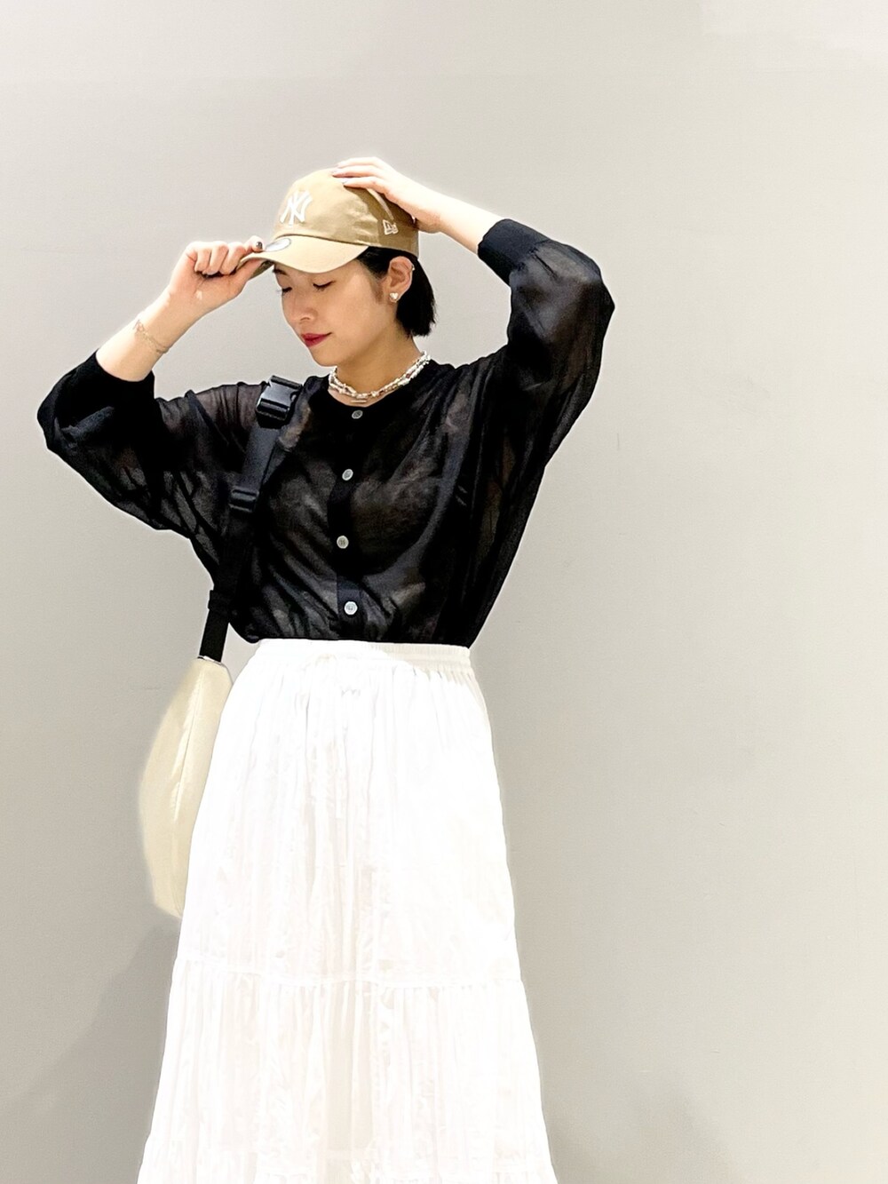 ブラック系のサンダル、ホワイト系のスカート、ホワイト系のショルダーバッグを着用したレディースの夏コーディネートの7枚目の写真