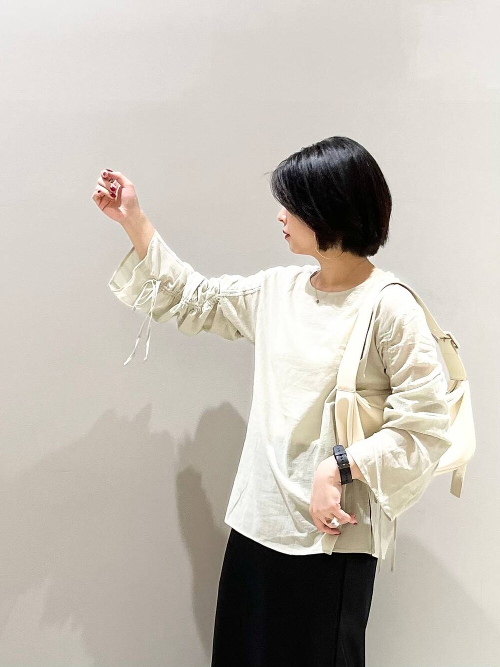 ホワイト系のショルダーバッグ、ブラック系のパンプス、ブラック系のスカートを着用したレディースの夏コーディネートの5枚目の写真