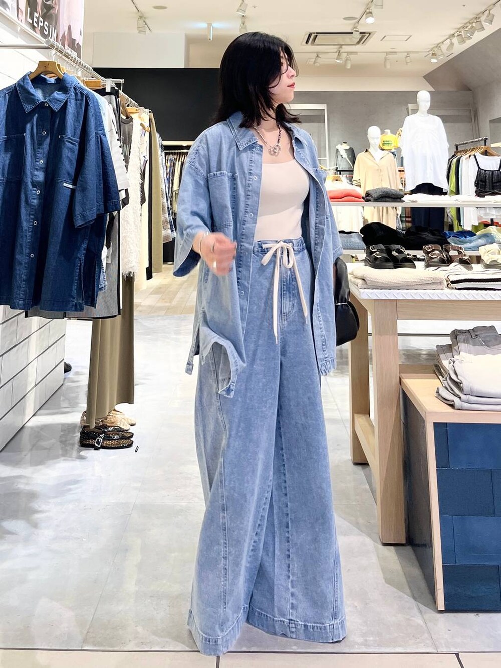 ブルー系のシャツ/ブラウス、ホワイト系のタンクトップ、ブルー系のデニムパンツを着用したレディースの春コーディネートの6枚目の写真