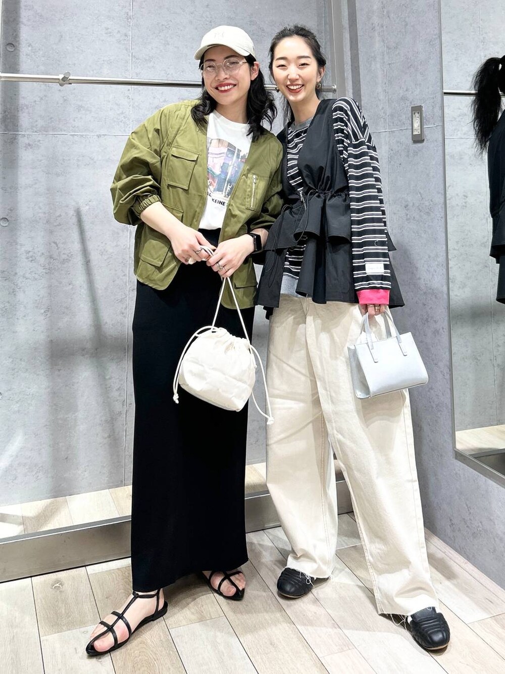 ブラック系のスカート、ホワイト系のショルダーバッグ、ブラック系のサンダルを着用したレディースの春コーディネートの5枚目の写真