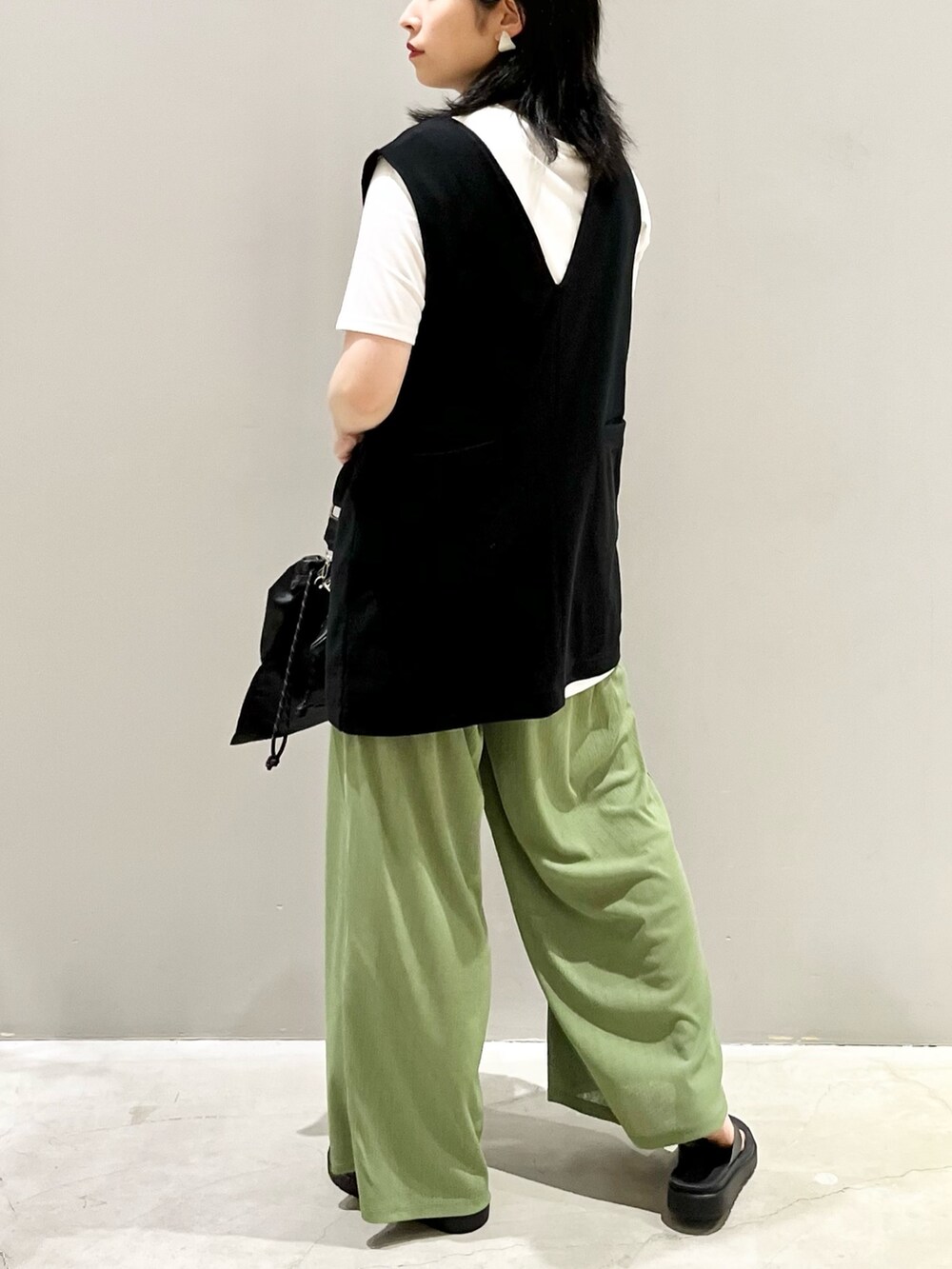 ブラック系のTシャツ/カットソー、ブラック系のサンダル、グリーン系のパンツを着用したレディースの秋コーディネートの2枚目の写真