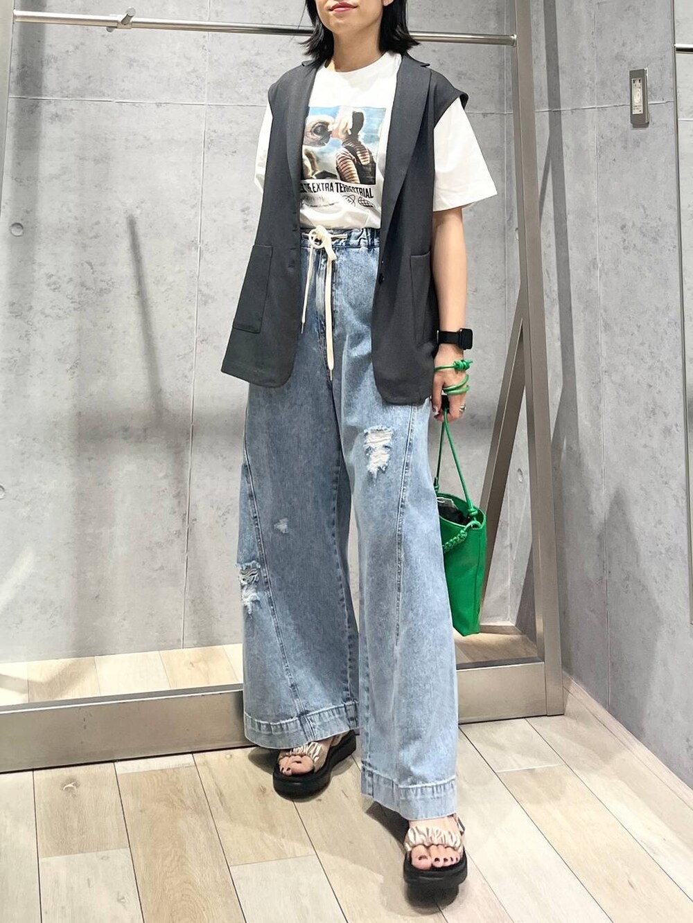 ベージュ系のサンダル、ブルー系のデニムパンツ、グリーン系のショルダーバッグを着用したレディースの夏コーディネートの4枚目の写真