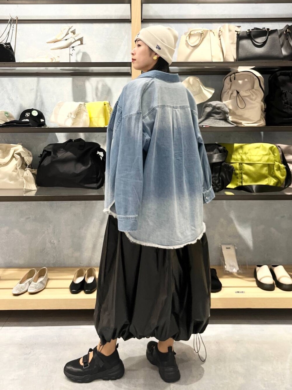 ブラック系のショルダーバッグ、ブラック系のTシャツ/カットソー、ブラック系のスニーカーを着用したレディースの春コーディネートの6枚目の写真