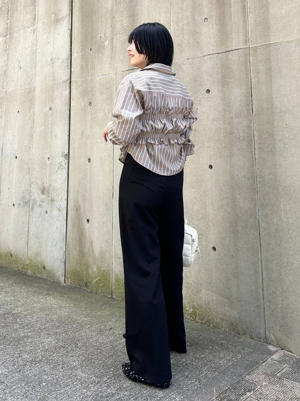 ブラック系のパンプス、ブラック系のその他パンツ、ホワイト系のボストンバッグを着用したレディースの秋コーディネートの5枚目の写真