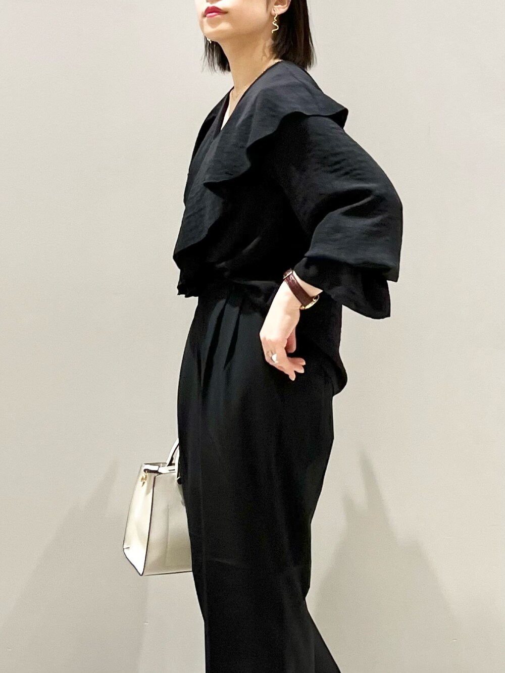 ブラック系のシャツ/ブラウス、ブラック系のバッグ、ブラック系のパンツを着用したレディースの春コーディネートの2枚目の写真