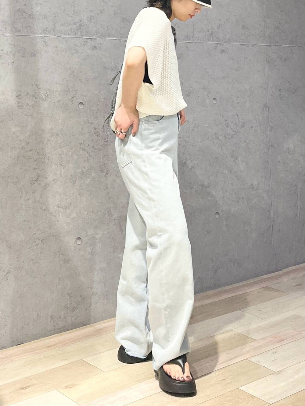 ブラック系のサンダル、ブルー系のデニムパンツ、ホワイト系のニット/セーターを着用したレディースの夏コーディネートの7枚目の写真