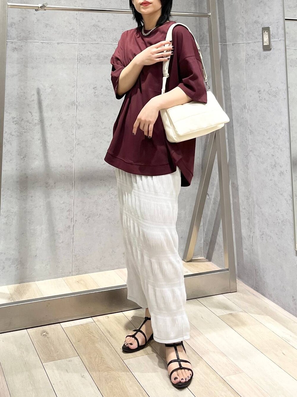 ホワイト系のショルダーバッグ、ブラック系のサンダル、レッド系のTシャツ/カットソーを着用したレディースの夏コーディネートの2枚目の写真