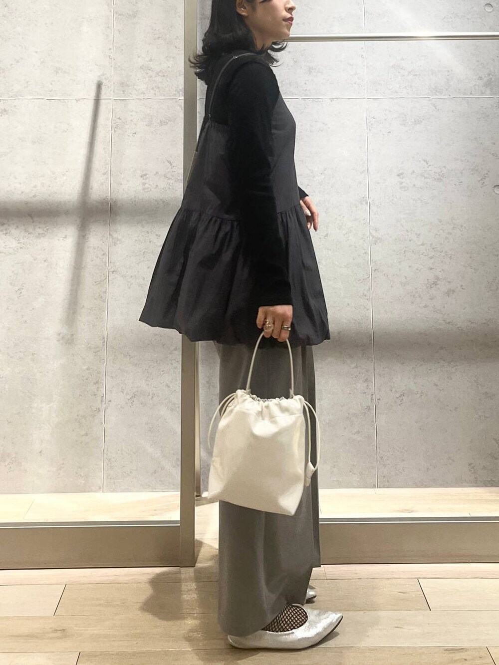 シルバー系のパンプス、ホワイト系のショルダーバッグ、グレー系のその他パンツを着用したレディースの春コーディネートの3枚目の写真