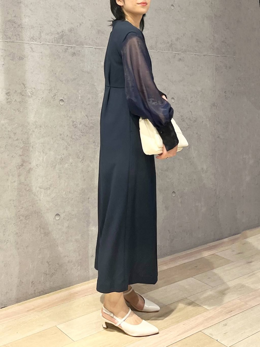 ホワイト系のショルダーバッグ、ホワイト系のパンプス、ブルー系のドレスを着用したレディースの夏コーディネートの4枚目の写真