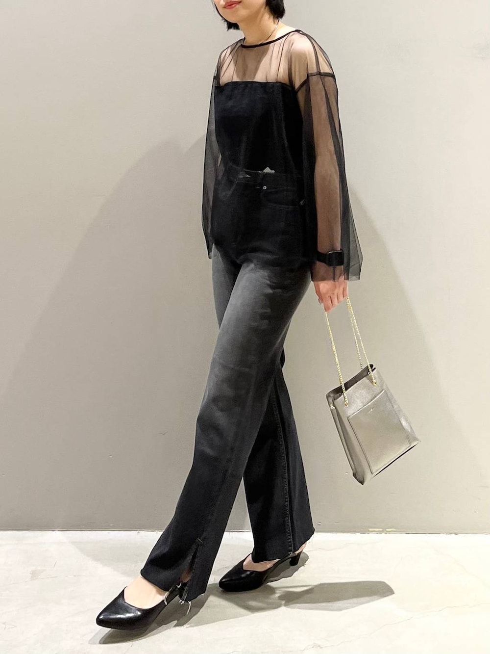 ブラック系のチューブトップ、ブラック系のTシャツ/カットソー、ブラック系のデニムパンツを着用したレディースの秋コーディネートの3枚目の写真