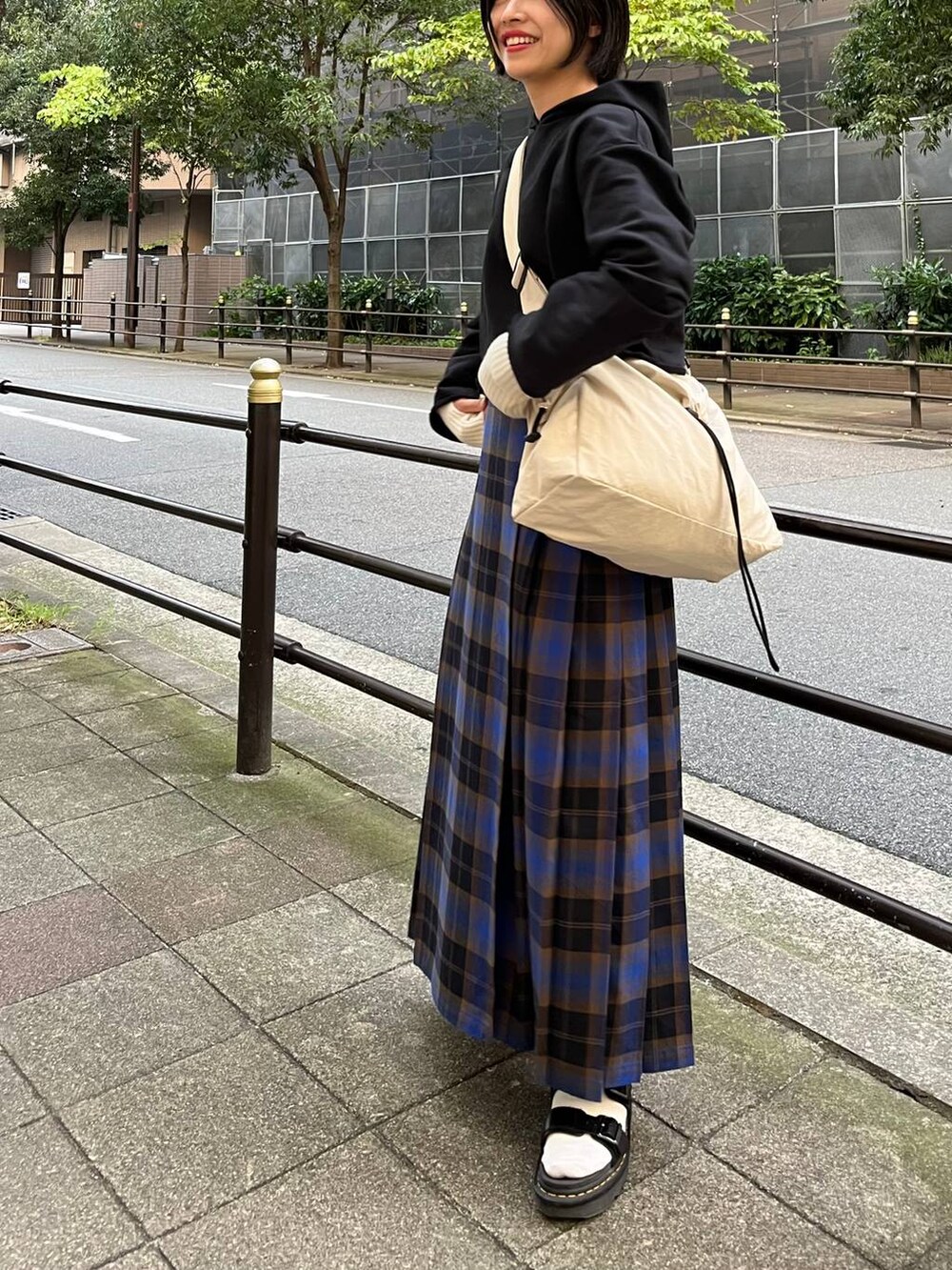 ブラック系のパーカー、ブルー系のスカート、ホワイト系のショルダーバッグを着用したレディースの秋コーディネートの8枚目の写真