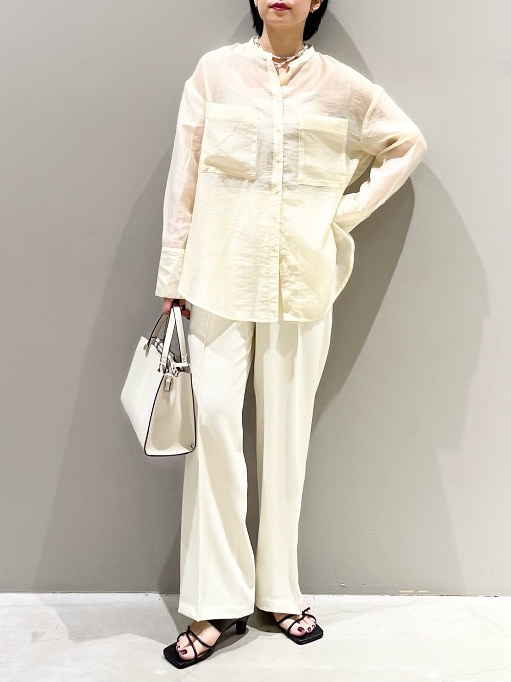 ホワイト系のシャツ/ブラウス、ホワイト系のスラックス、ホワイト系のショルダーバッグを着用したレディースの夏コーディネートの5枚目の写真