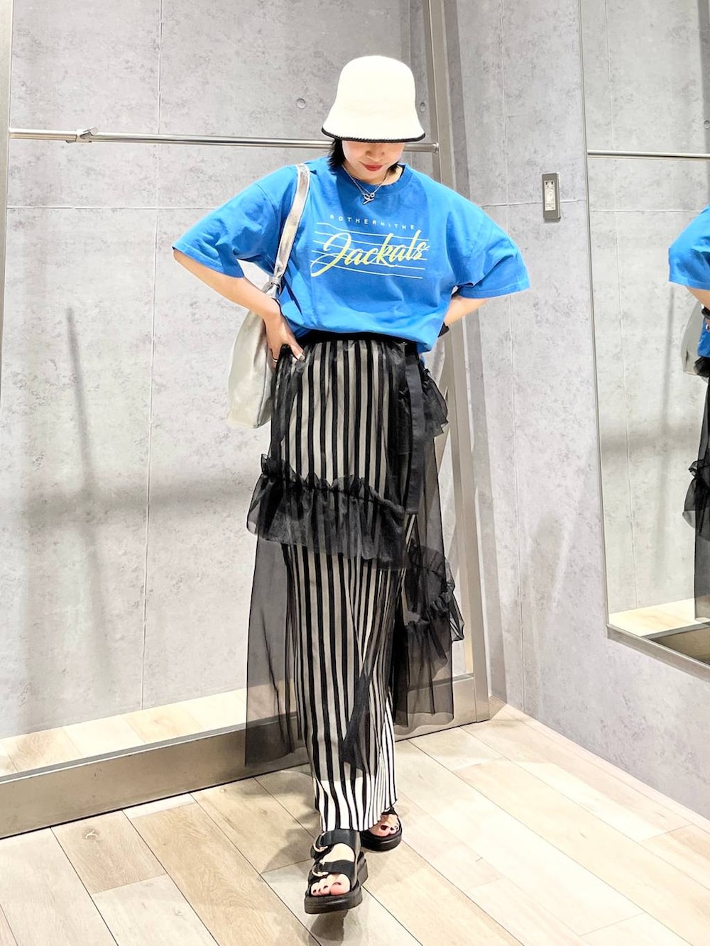 ホワイト系のスカート、ブルー系のTシャツ/カットソー、ブラック系のサンダルを着用したレディースの春コーディネートの7枚目の写真