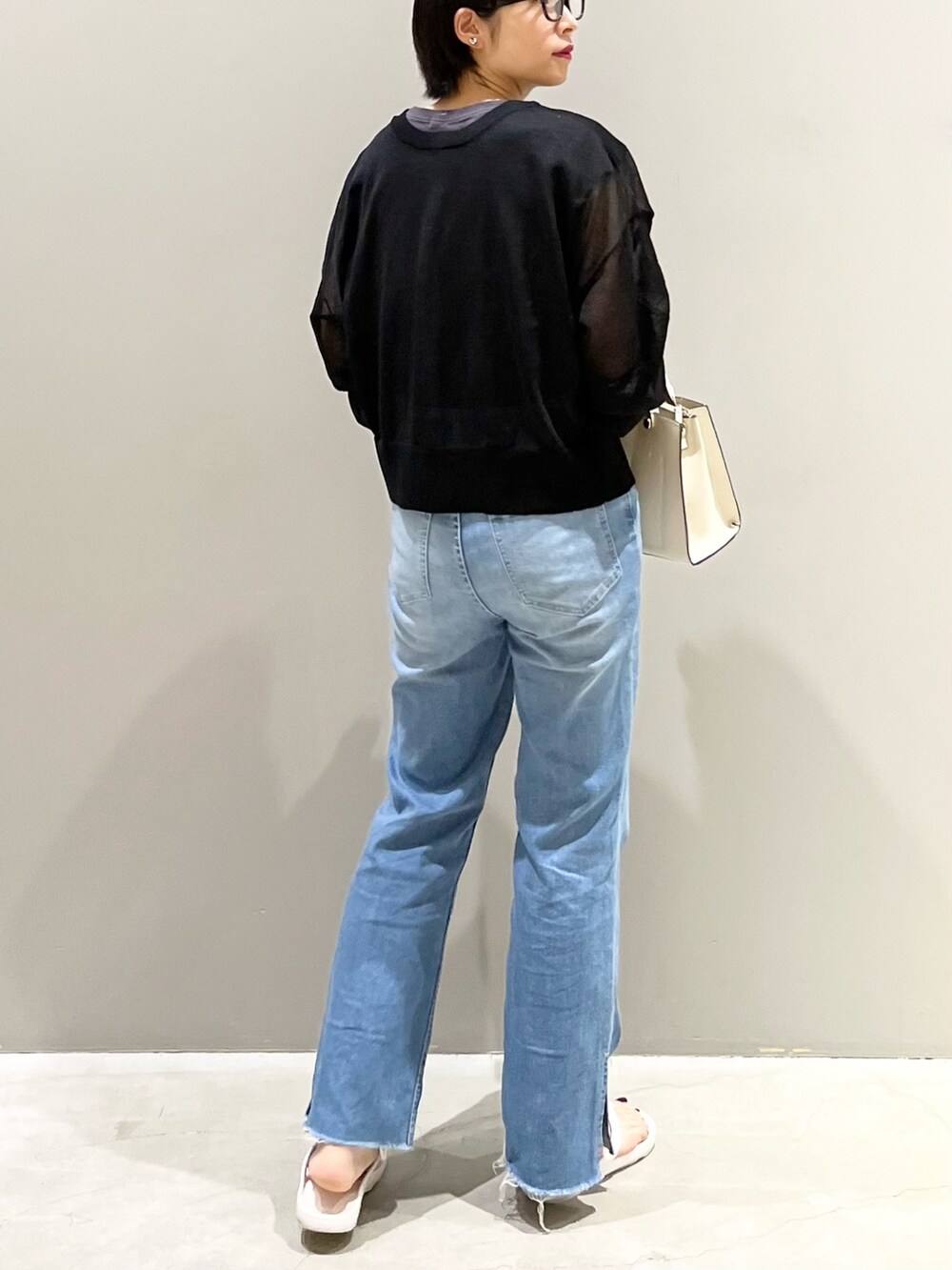 ホワイト系のサンダル、ホワイト系のショルダーバッグ、ブルー系のデニムパンツを着用したレディースの夏コーディネートの5枚目の写真