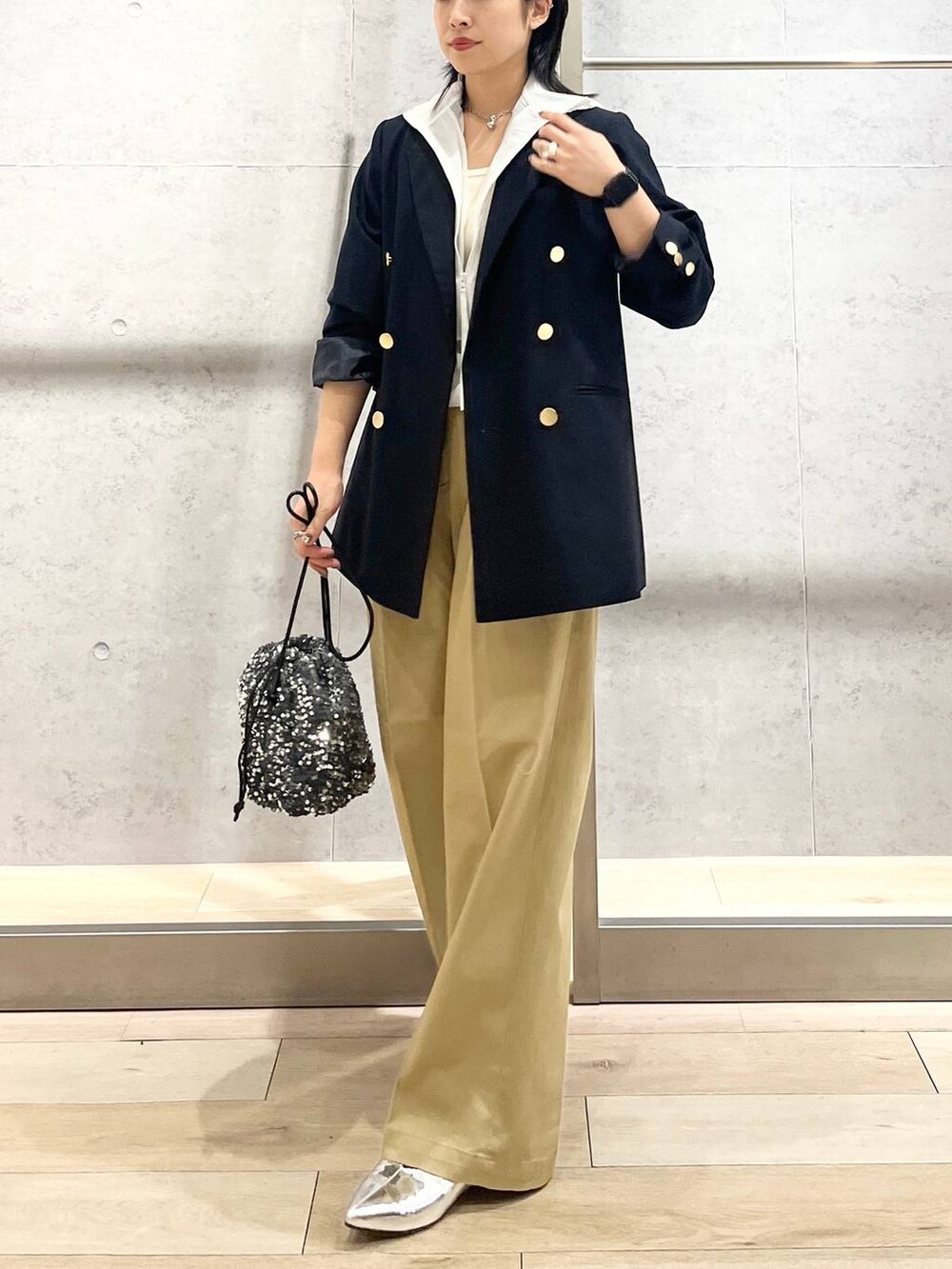 ブルー系のテーラードジャケット、ベージュ系のチノパンツ、ホワイト系のタンクトップを着用したレディースの夏コーディネートの3枚目の写真