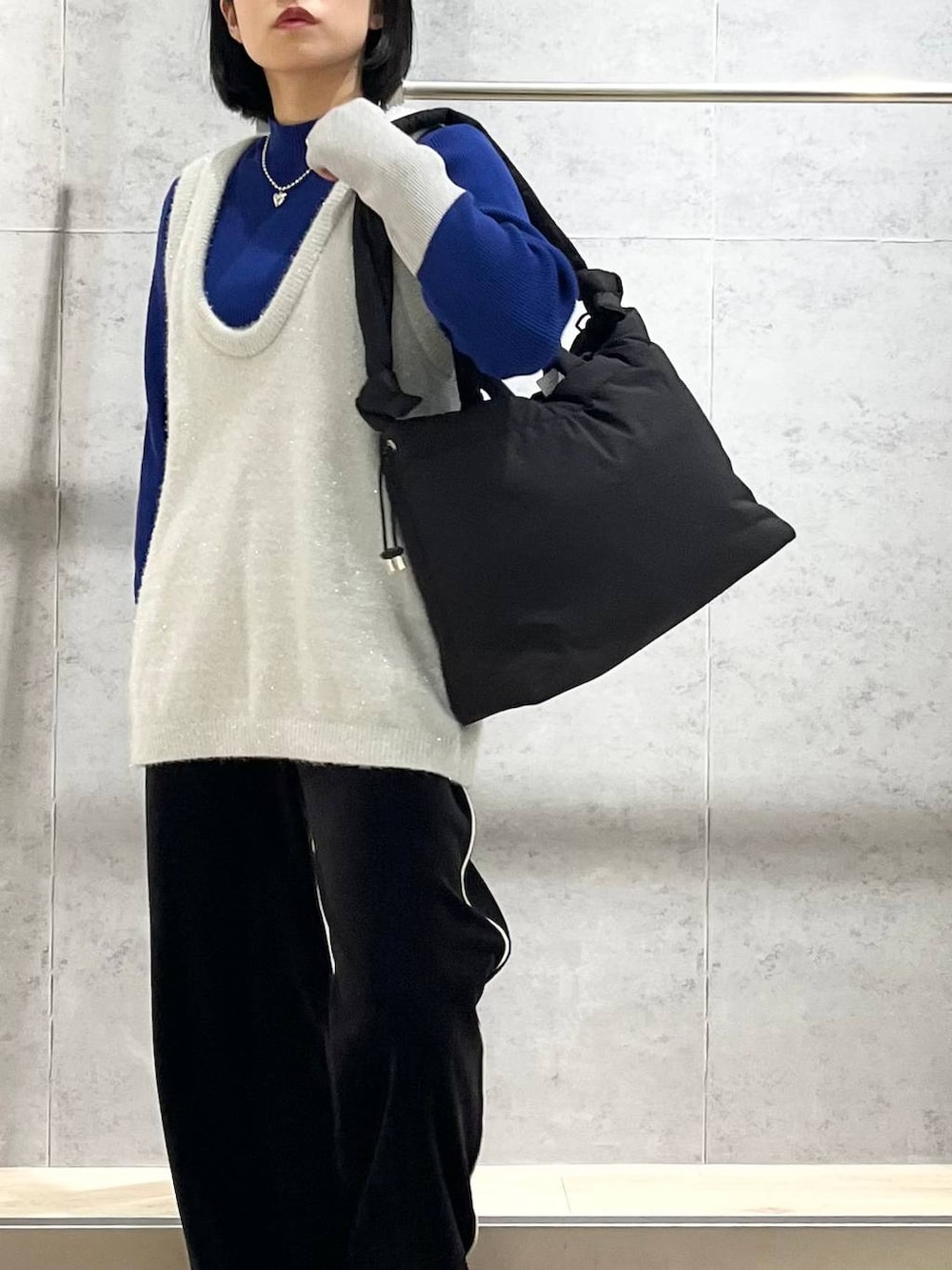 ブラック系のブーツ、ブルー系のニット/セーター、ブラック系のその他パンツを着用したレディースの冬コーディネートの3枚目の写真