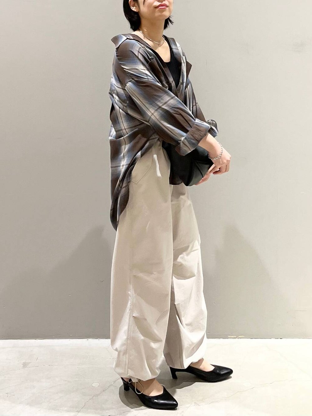 ブラウン系のシャツ/ブラウス、ホワイト系のその他パンツ、ブラック系のハンドバッグを着用したレディースの夏コーディネートの5枚目の写真