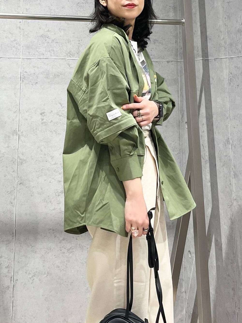 ブラック系のショルダーバッグ、ブラック系のサンダル、シルバー系のキーホルダーを着用したレディースの春コーディネートの2枚目の写真